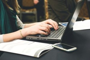 A woman typing on a laptop, presumably staying productive while traveling.