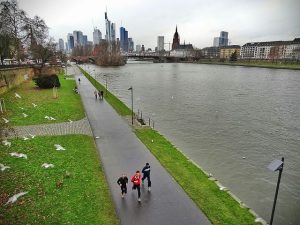 People jogging in Frankfurt am Mein. Could be on a business trip, or they could just live there. We don't know.