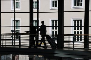 Business traveler walking through an airport. You can still fly even if you're trimming your travel budget.