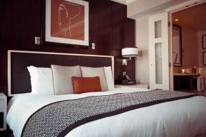 Don't fall for the hotel mattress hype. Photo of a hotel bed with pillows and some art on the wall.