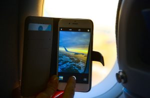 A photo of a smartphone taking a photo of a plane wing. More people are using smartphones to book their travel.