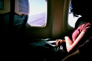 A woman business traveler sitting on an airplane. Business travel can help entrepreneurs improve the way they work and function.