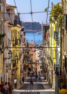 Looking down a hill through a long row of buildings in Portugal. It's important to do research before you experience an emergency abroad.