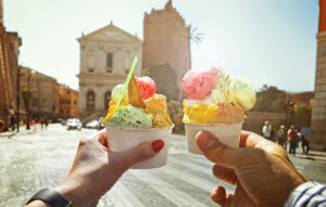 Two people toasting with cups of ice cream. You can enjoy different tasty treats as you travel the world, even from your own kitchen.