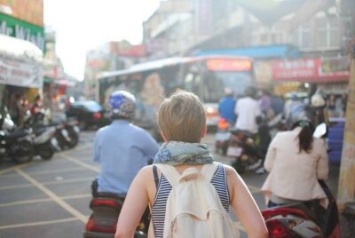 Young woman walking in a busy city. Consumer confidence in travel is growing.