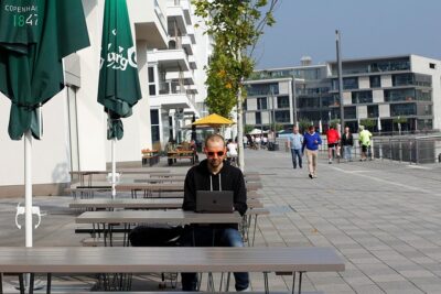 A guy working at an empty outdoor cafe. You can lead a life of never-ending if you have the right kind of job.