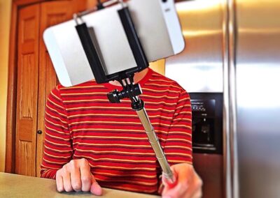 Someone holding a selfie stick. These are one of the travel gadgets you should avoid.